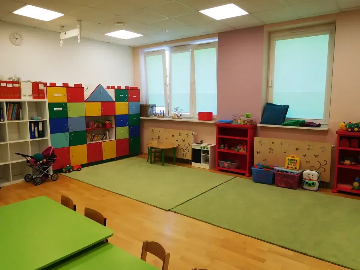 Przestronna sala przedszkolna z zabawkami i kącikami zabaw