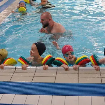 Dzieci podczas nauki pływania na basenie w przedszkolu Czarodziejski Dworek
