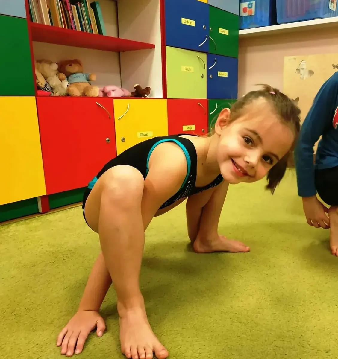 Dziecko podczas ćwiczeń ruchowych na macie